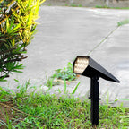 Adjustable solar spike spotlight aimed at green garden bushes