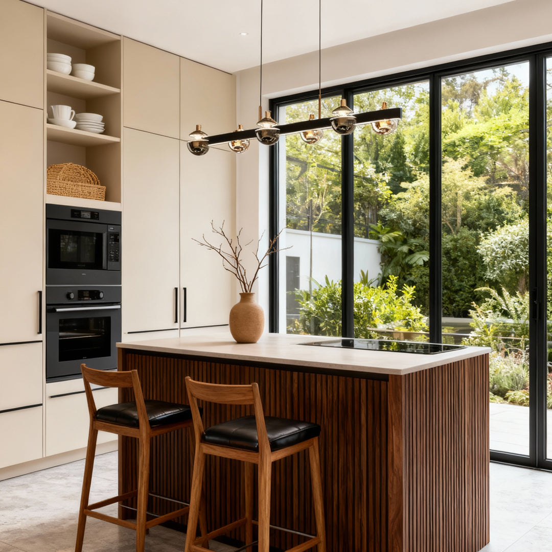 Black and gold chandelier above a kitchen island with garden views