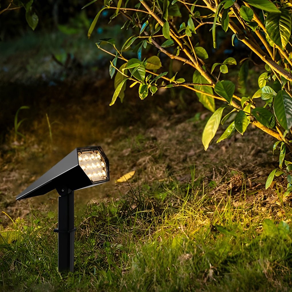 Black spike spotlight among grass and plants at night