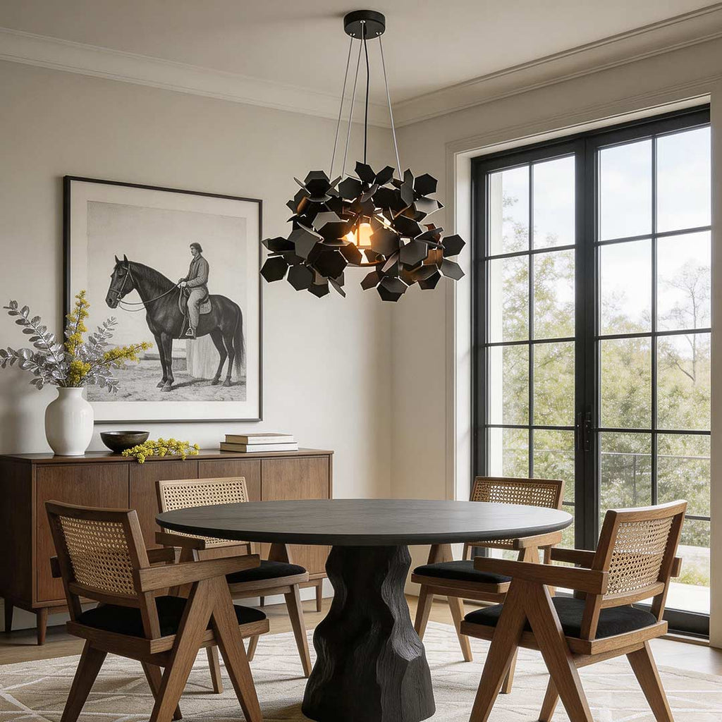 Black leaf design chandelier above a modern dining table