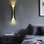 Black and gold up down wall light in a bedroom