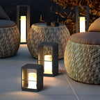 Black lantern casting soft light over poolside furniture