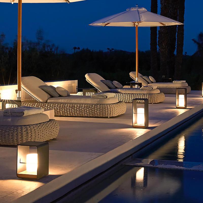 Open-frame lantern on a cozy patio beside wicker chairs
