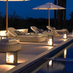 Open-frame lantern on a cozy patio beside wicker chairs