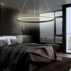 Black LED ring chandelier hanging above a bedroom bed