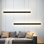 Black linear sconce mounted vertically in a cozy living room