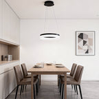 Black ring pendant light installed above a dining room table