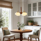 Walnut and brass chandelier giving warm light in a classic dining room