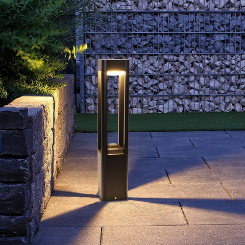 Bollard landscape light beside a stone wall entry