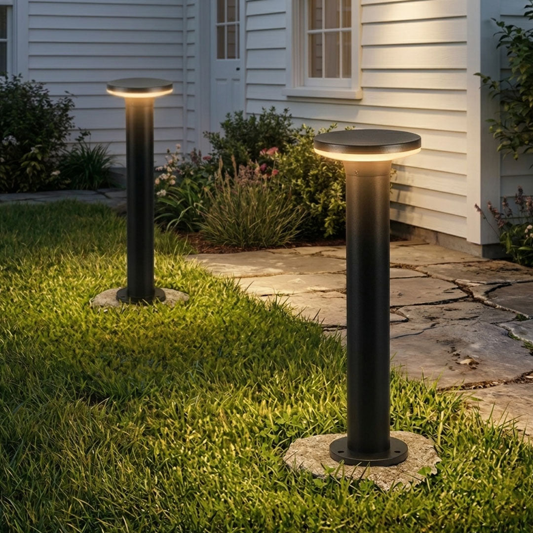 Modern bollard light glowing in an outdoor garden
