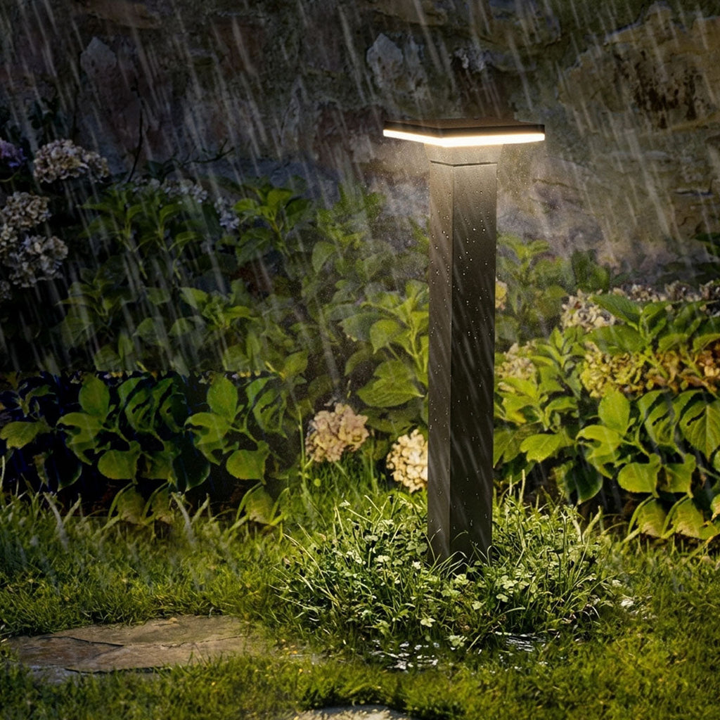 Bollard pathway lights lining a walkway beside a driveway