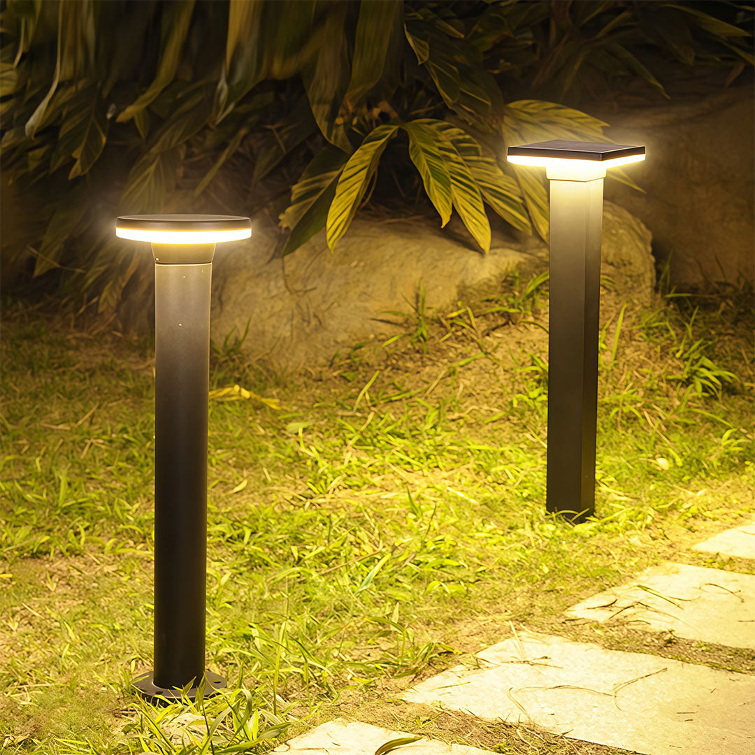 Bollard pathway light standing in a garden yard at night