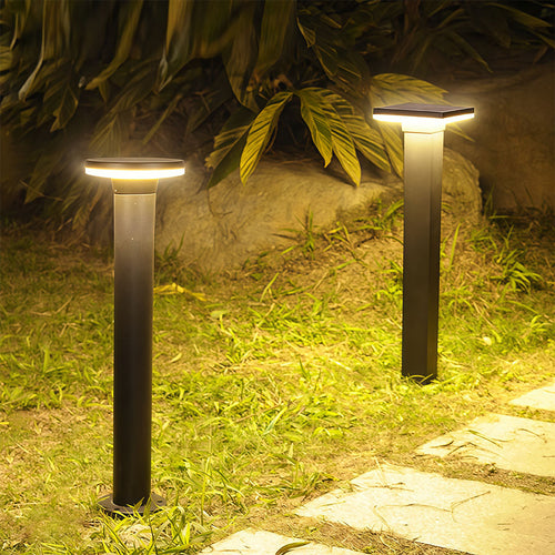Bollard pathway light standing in a garden yard at night