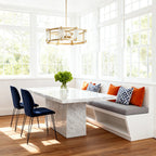 Round glass chandelier in a bright sunroom with marble bench
