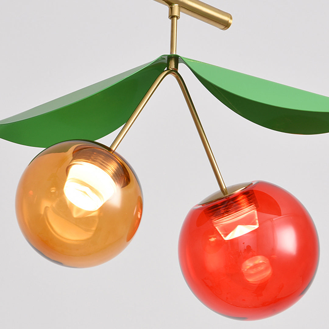 Detail of a glossy cherry pendant and brass stem