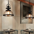 Clear glass bowl pendant light hanging in a cafe setting