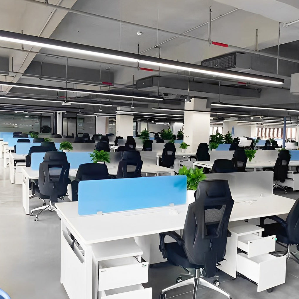 Row of linear pendant lights above an open office