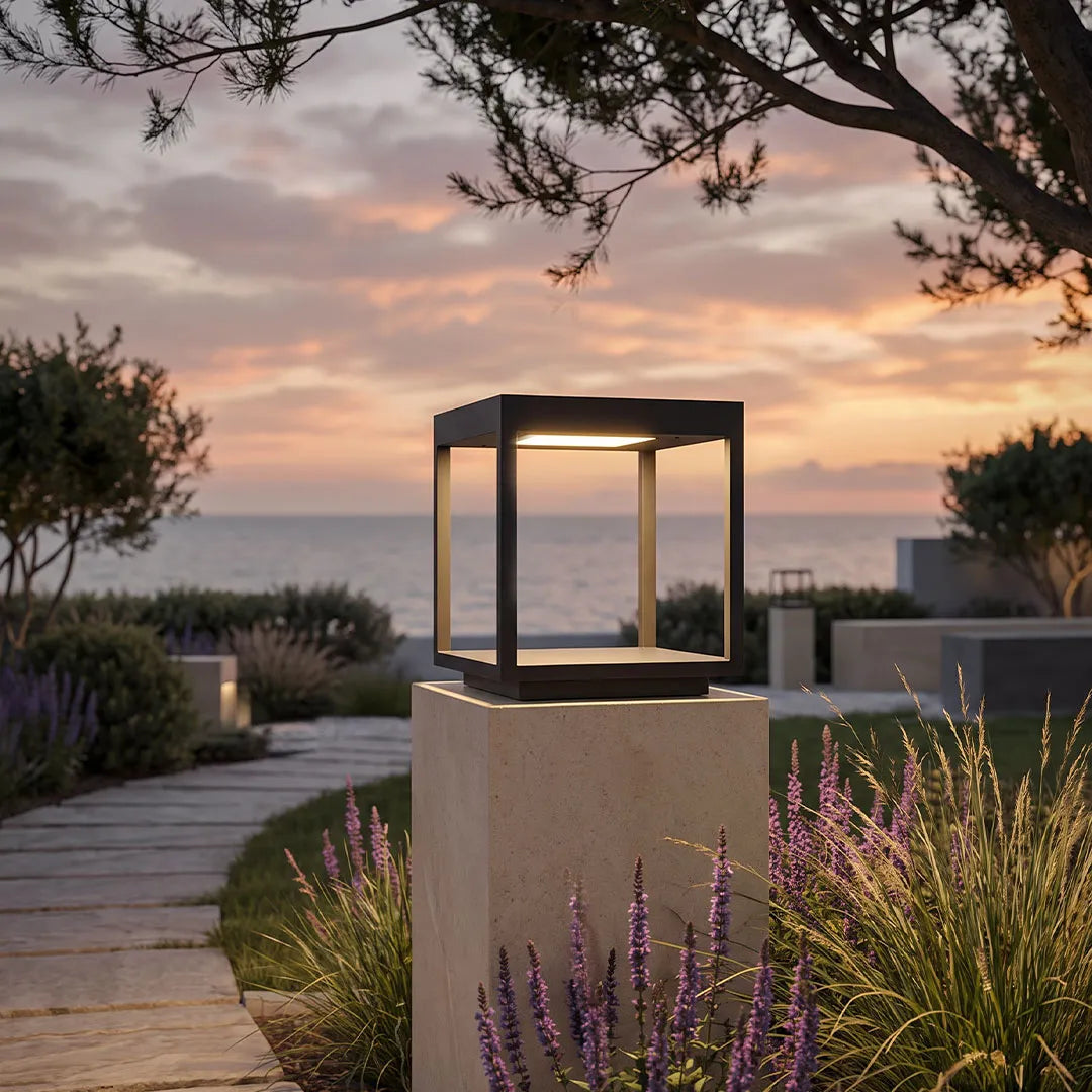 Open-frame pillar light on a garden column at sunset