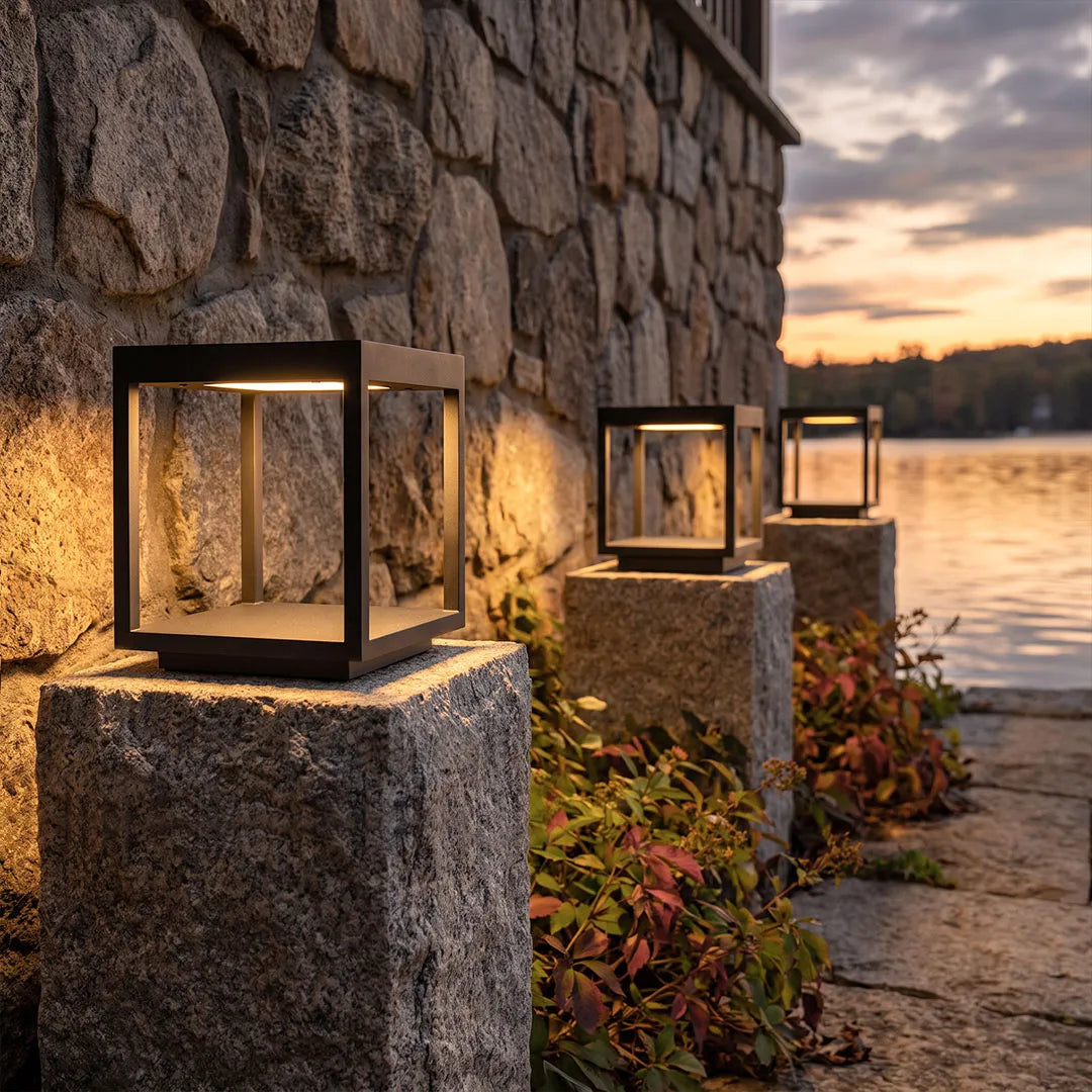 Open-frame pillar lights on stone columns beside the waterfront