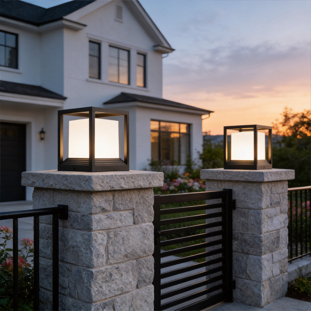 Garden pedestal lights on stone gate posts outside a house