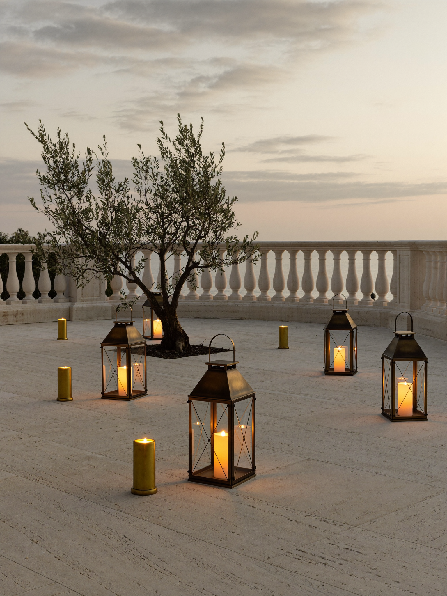 Outdoor lanterns glowing at golden hour on a stone terrace