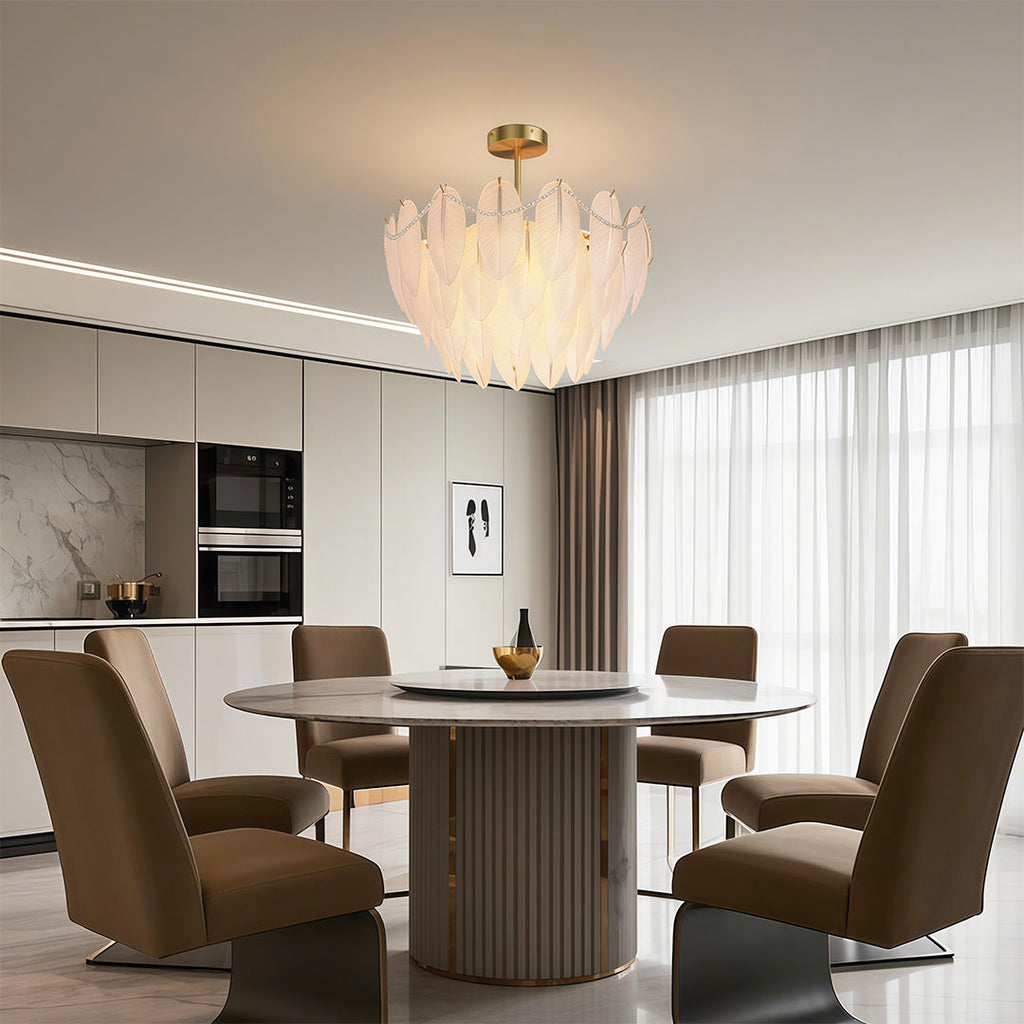 Pearl feather chandelier above elegant velvet dining chairs