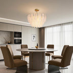 Pearl feather chandelier above elegant velvet dining chairs