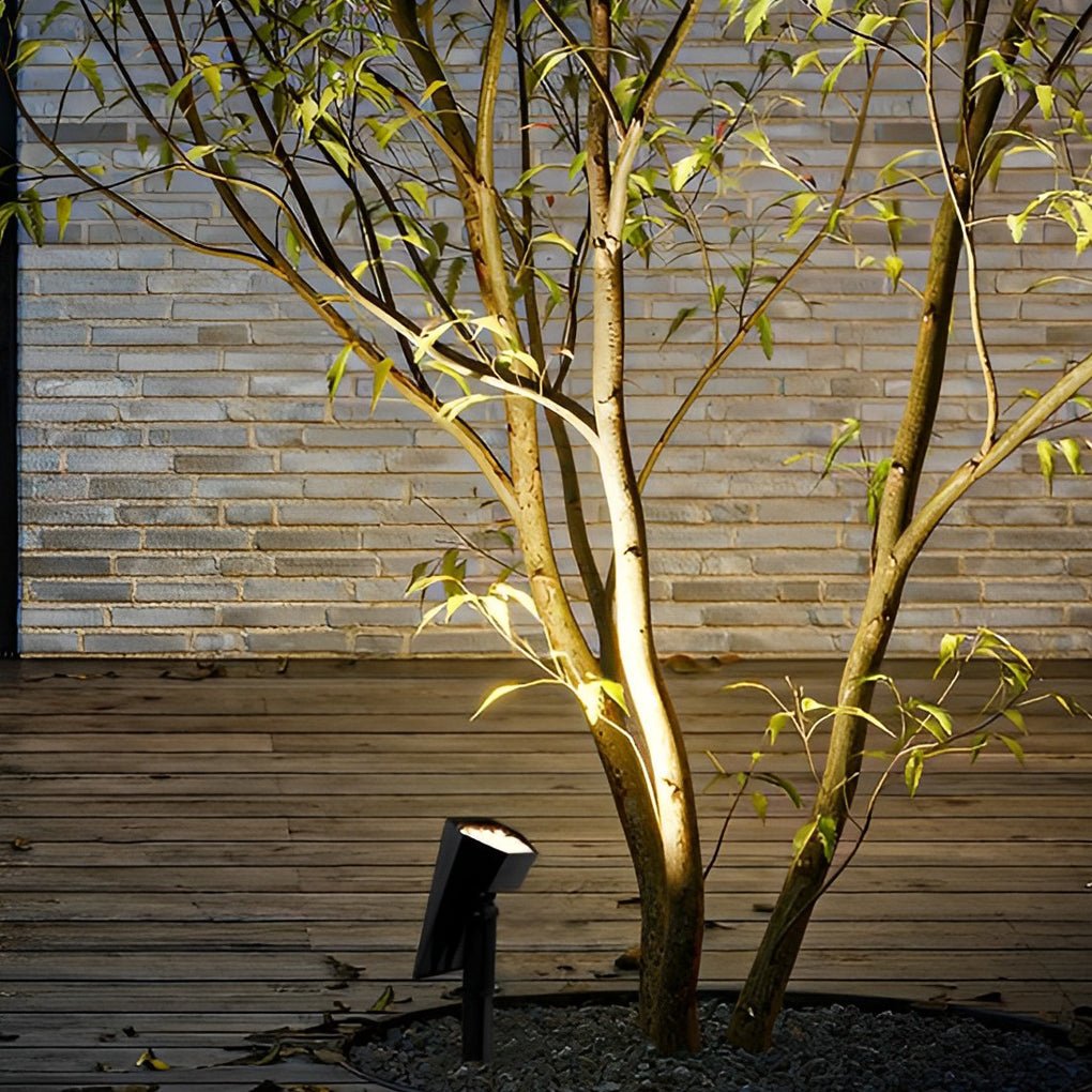 Spike spotlight lighting a small tree beside a wooden deck