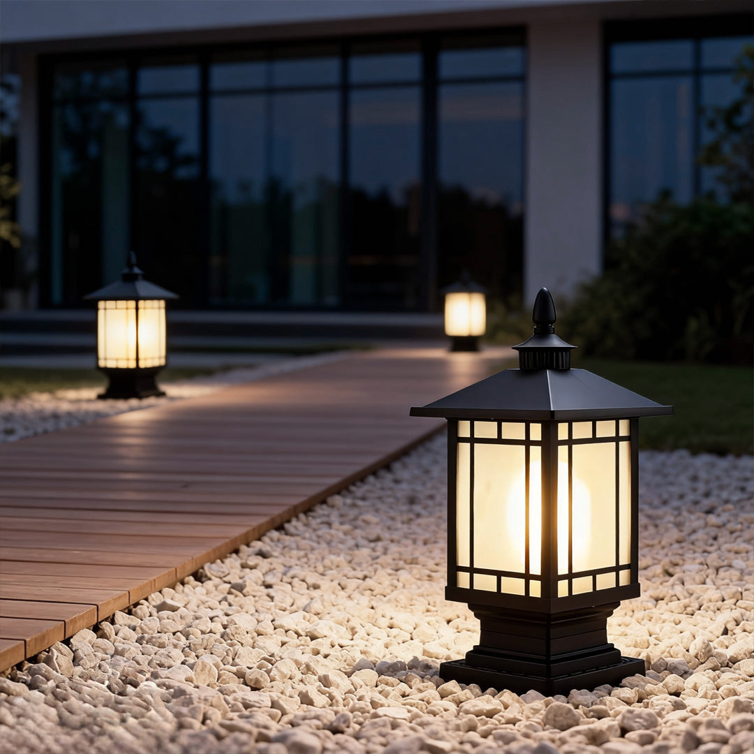 Post lantern lighting a garden pathway at night