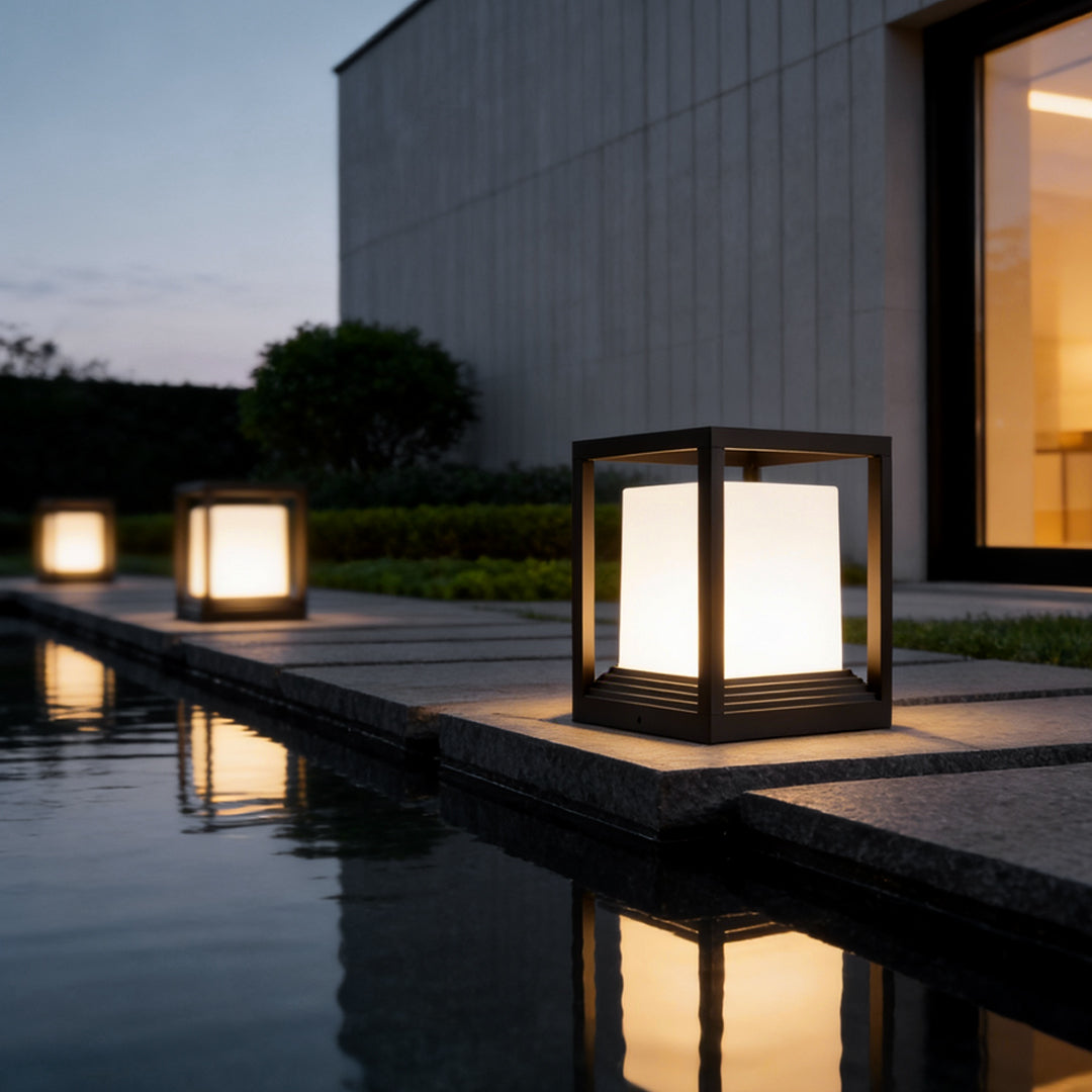 Pedestal lights glowing warmly beside an infinity pool
