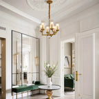 Glass drop chandelier in a neutral room beside artwork