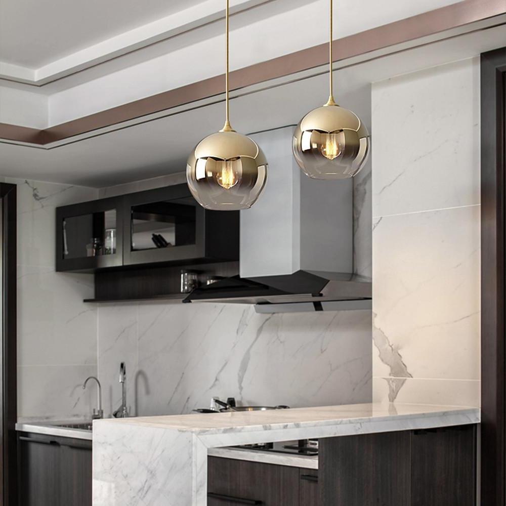 Glass globe pendant light above a marble kitchen counter