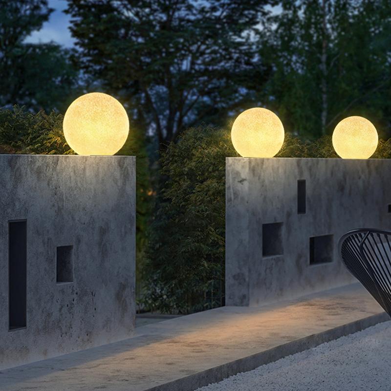 White globe pillar light on a concrete wall entryway