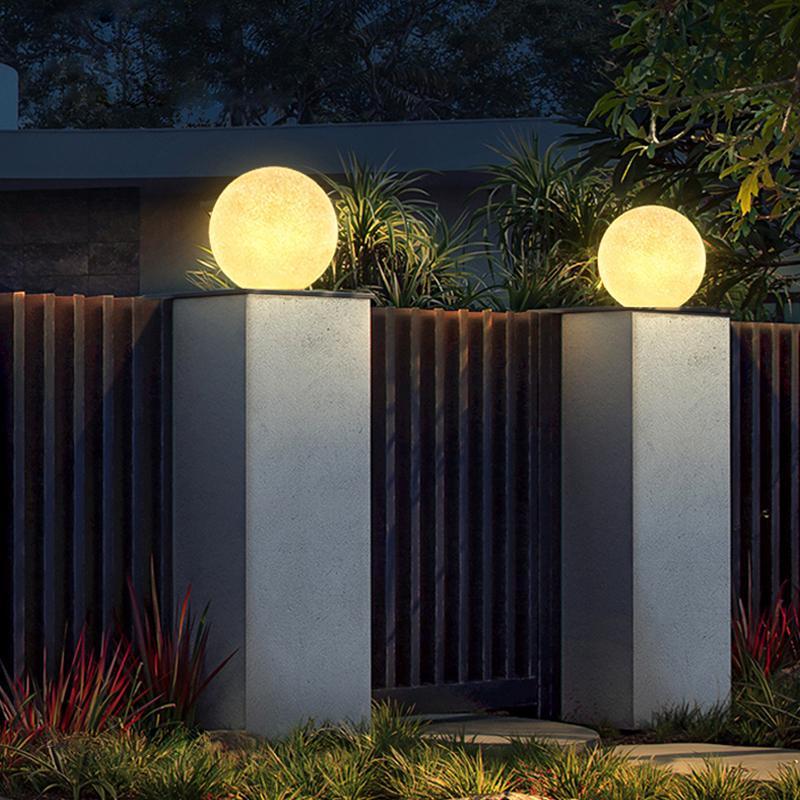 White globe pillar light on a modern yard wall