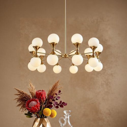 Gold bubble chandelier with frosted shades beside floral decor