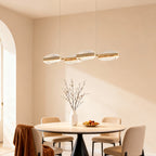 Gold chandelier above a dining table with wooden chairs