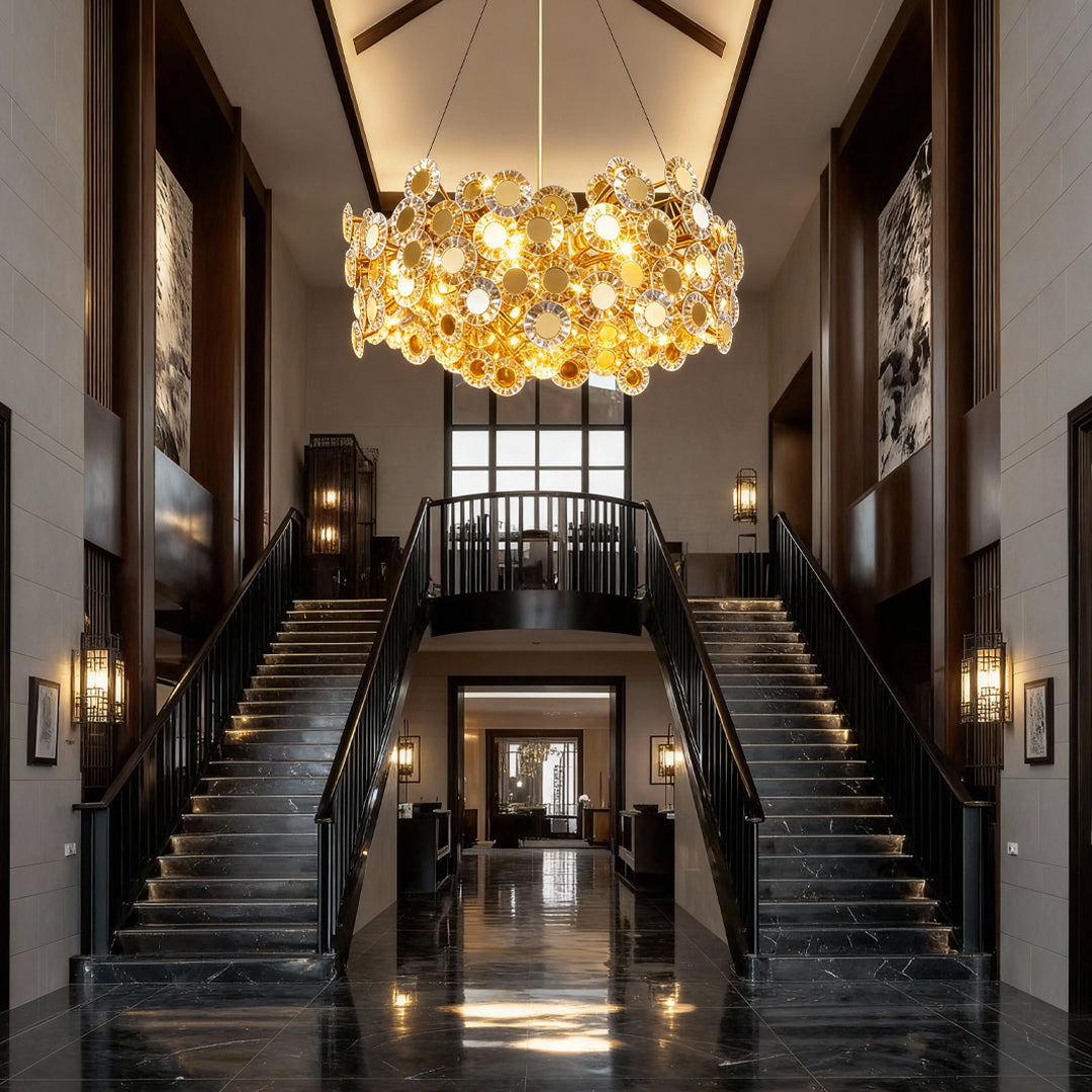Gold chandelier in a grand entryway with dual staircases