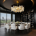 Gold chandelier above a marble table with skyline views
