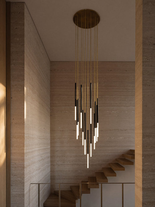 Modern staircase chandelier with matte black cylindrical LED pendants cascading through a travertine stairwell