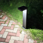 L-shaped path light casting warm light on a brick pathway