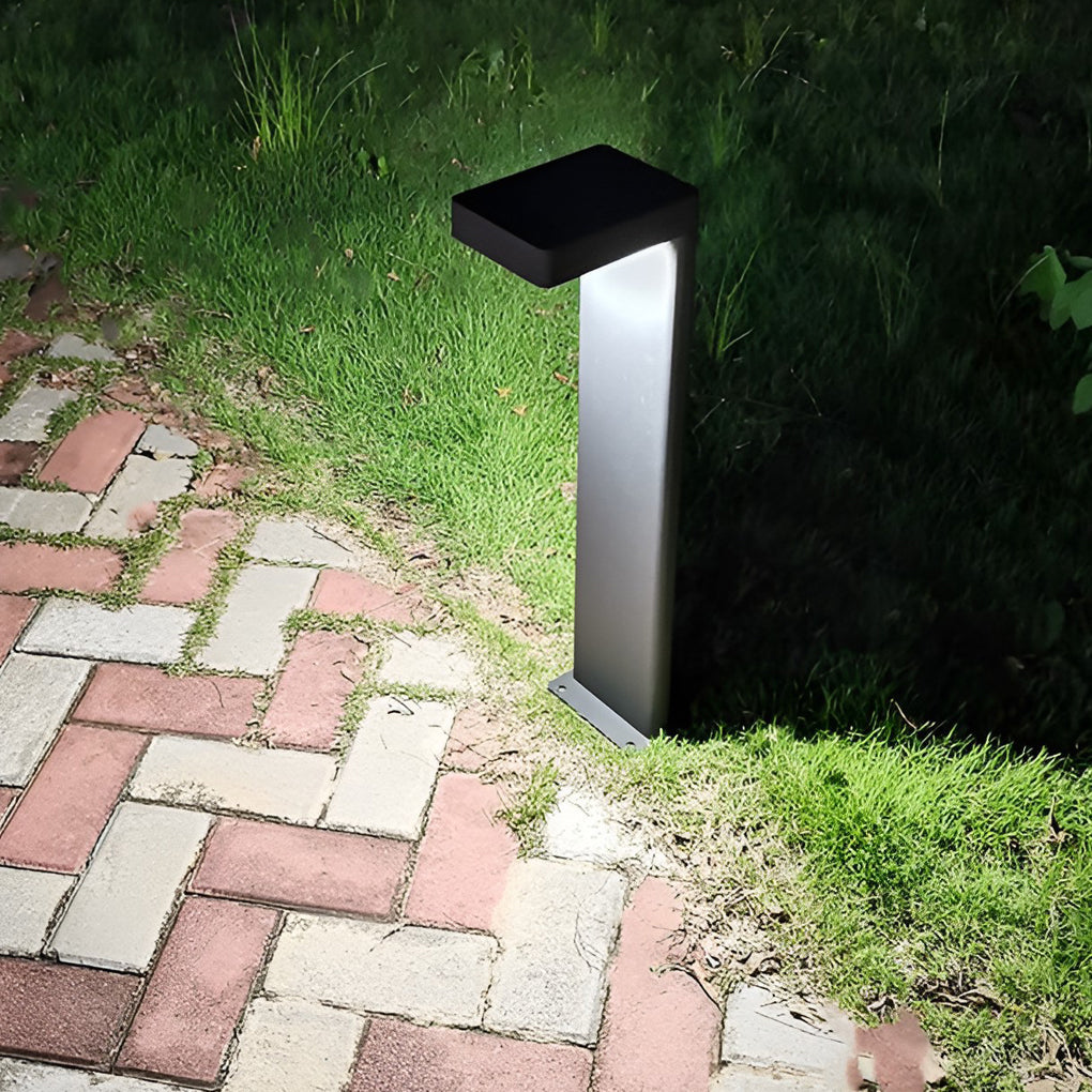 L-shaped path light casting warm light on a brick pathway