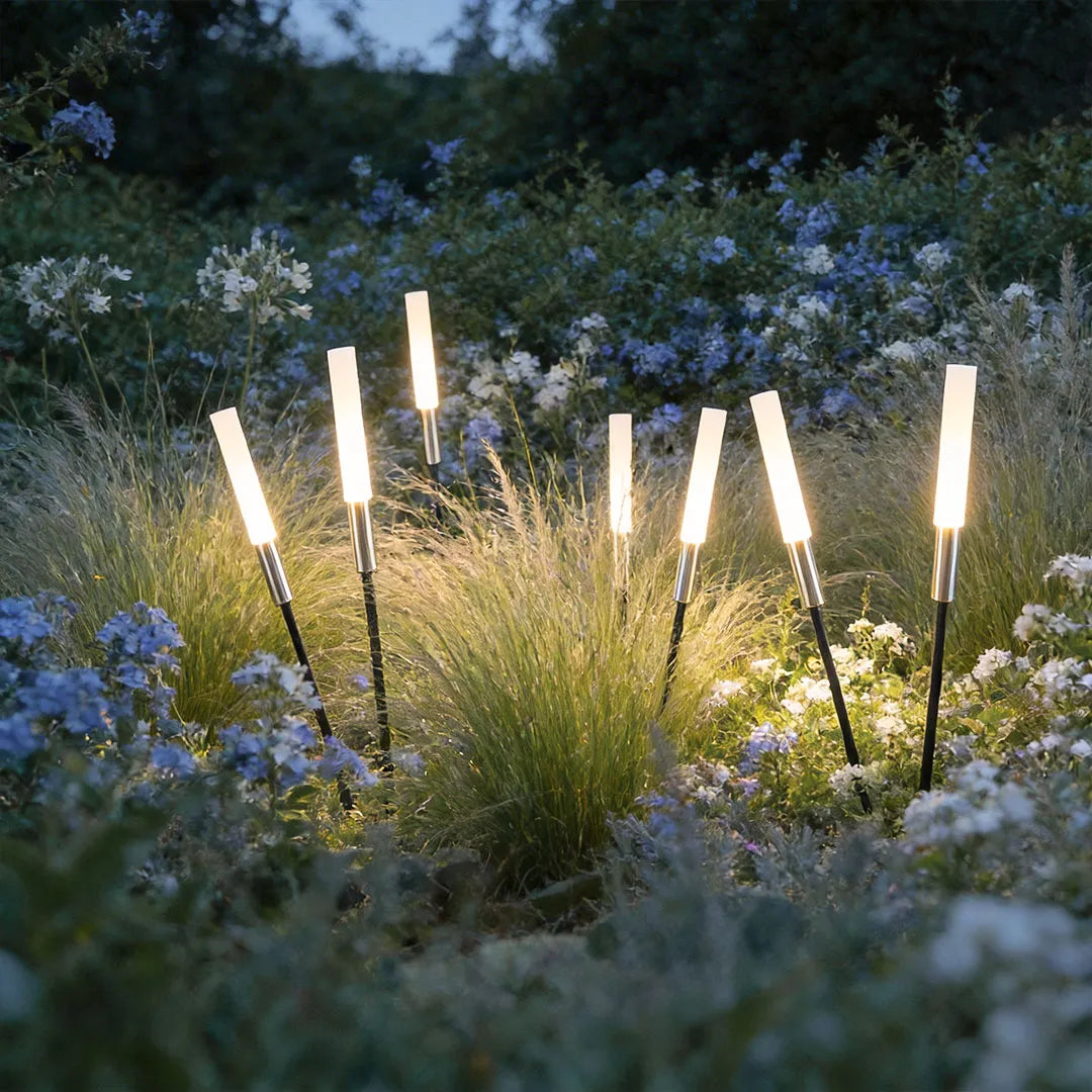 Spike lights among ornamental grass in a flower bed