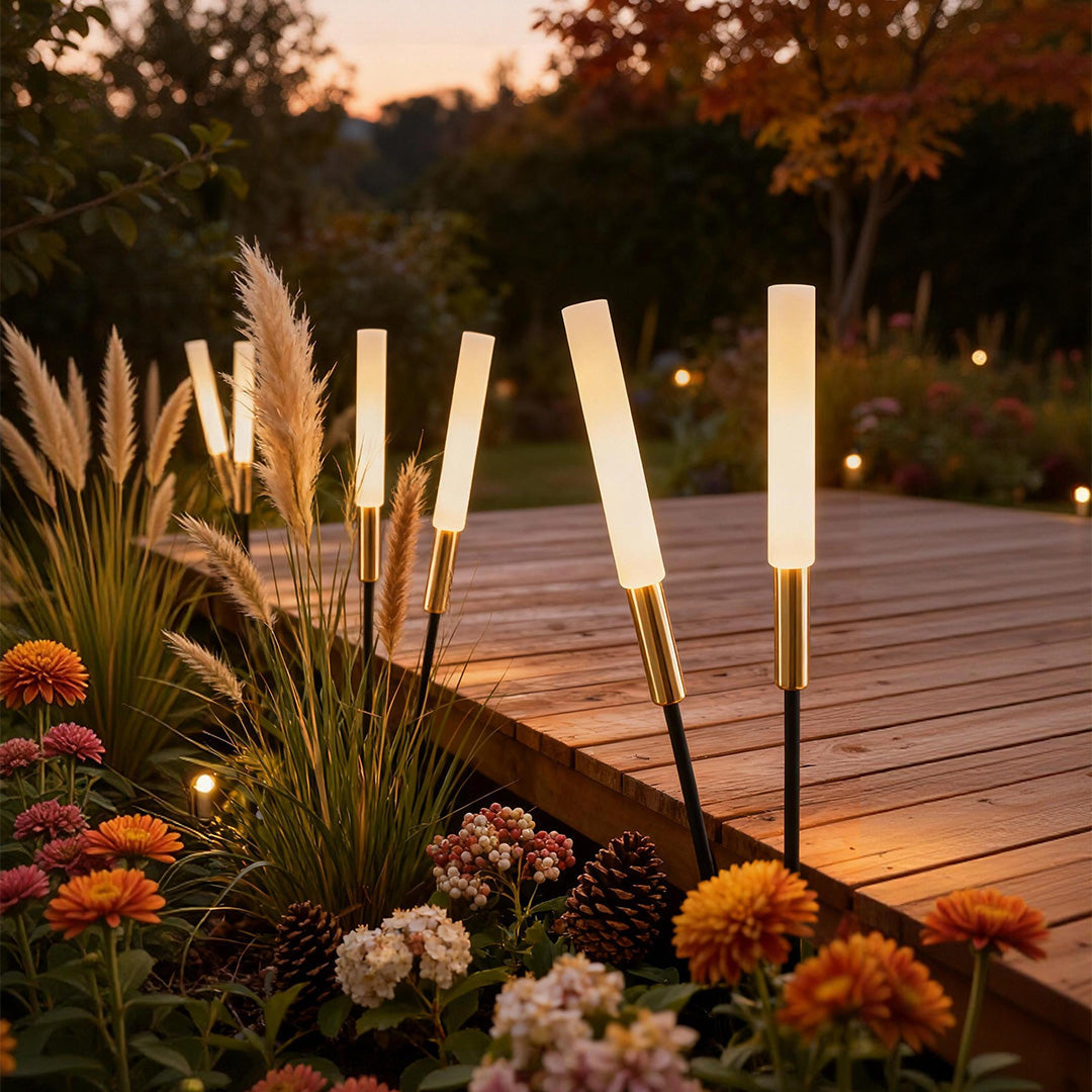 Spike lights among ornamental grasses beside a wooden deck