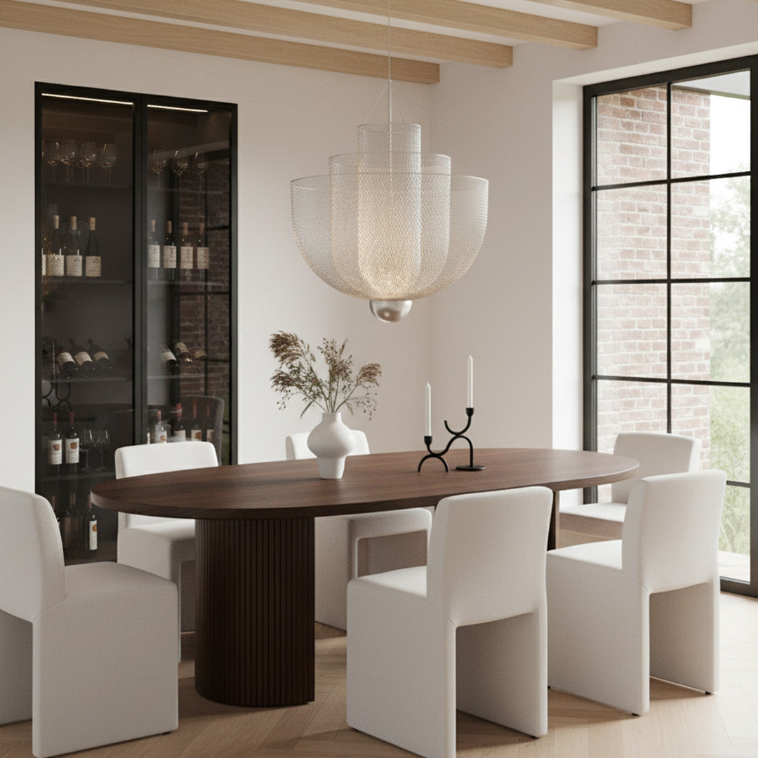 Large tiered silver mesh chandelier above a dark wood oval table