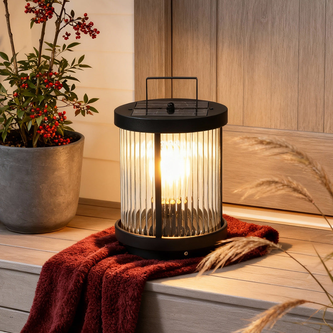 Solar lantern glowing warmly on a patio among potted plants
