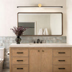 Linear vanity light bar in a modern wood bathroom
