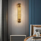 Crystal wall light glowing warm in a stylish bedroom