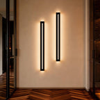 Pair of long black wall sconces lighting a hallway