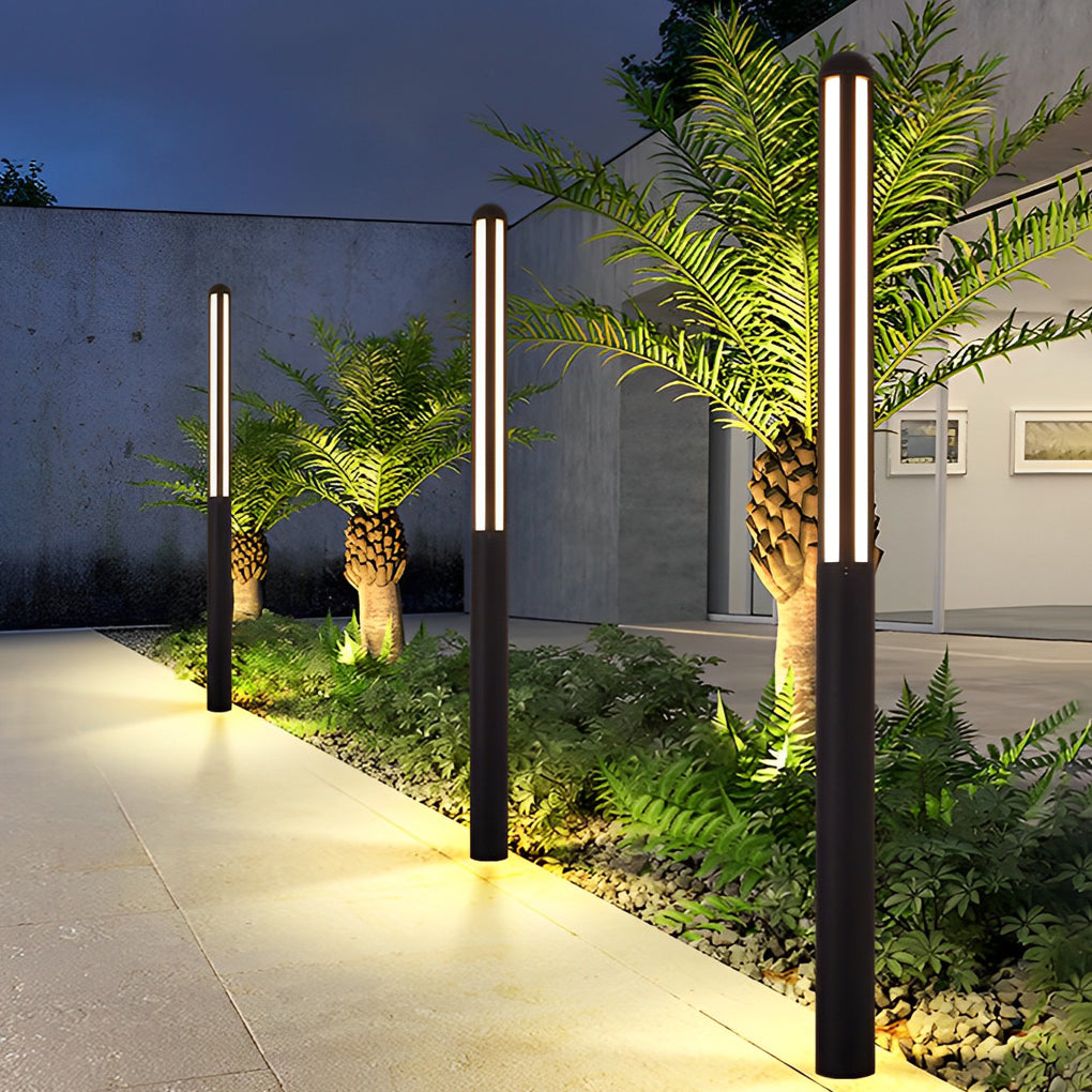 Minimalist tall bollard light beside a pool lounge area