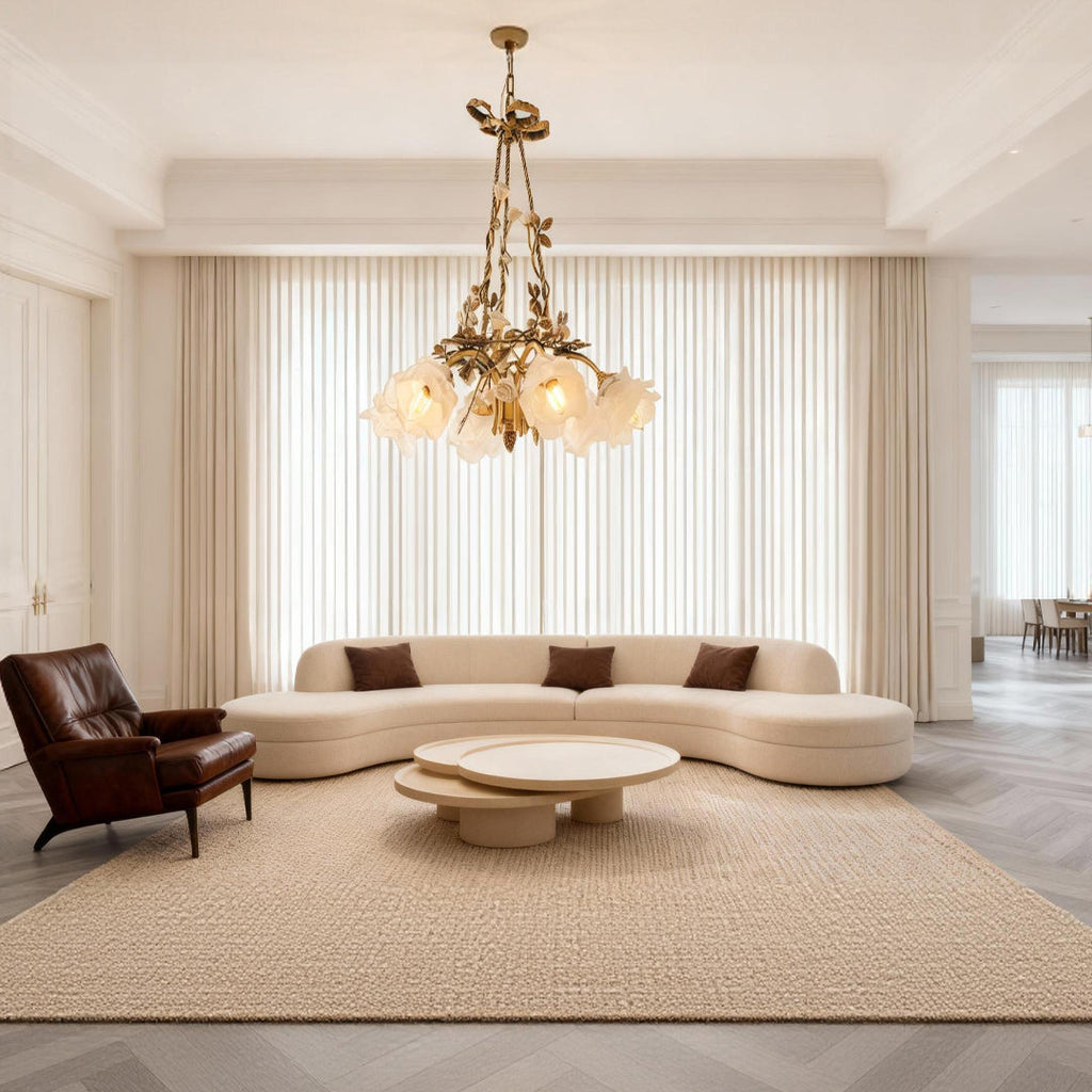 Flower chandelier above a curved sofa in a minimalist living room